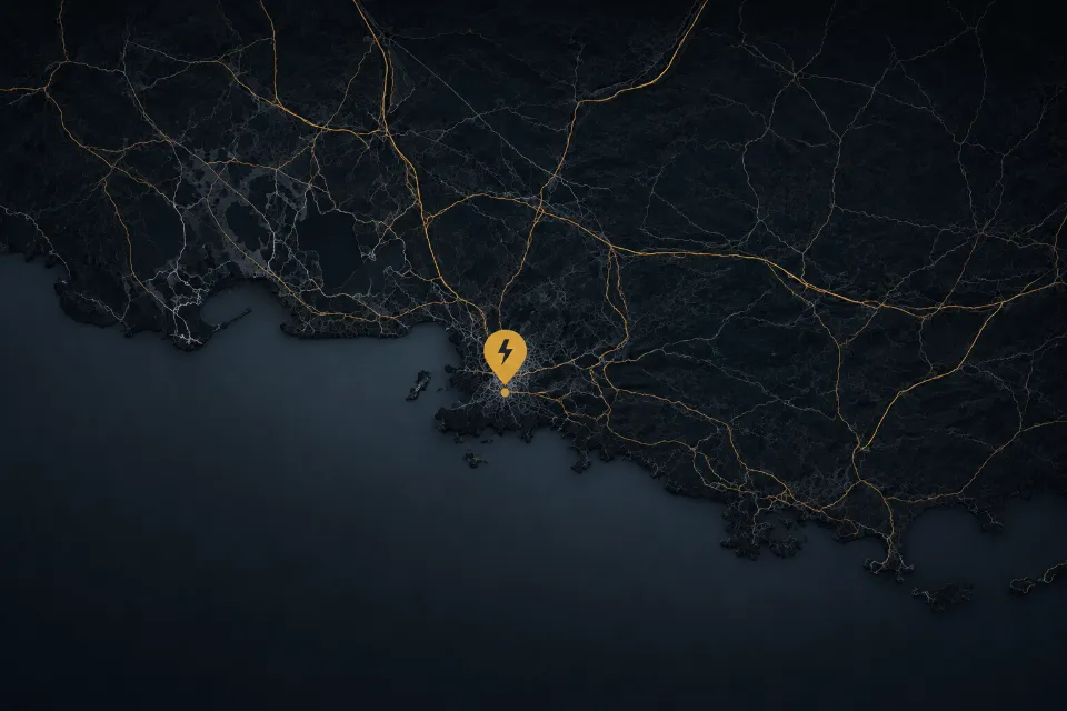 Carte aérienne nocturne de la région PACA avec des réseaux et des lumières jaunes formant des routes, un marqueur jaune avec un symbole de foudre au centre qui indique Marseille.
